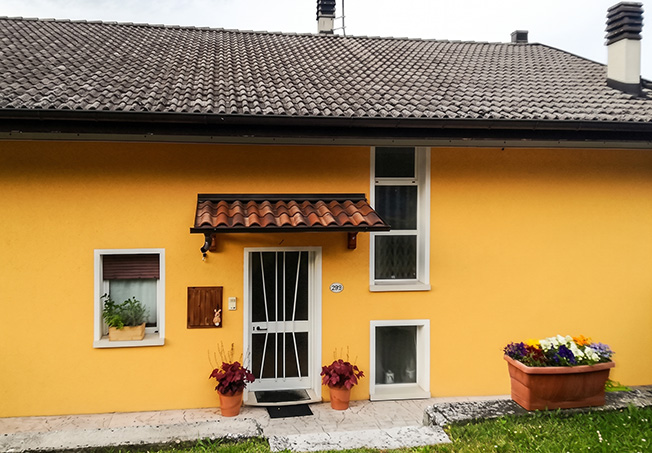 Exterior of a detached house with a Clivet AQUA heat pump system and photovoltaics for hot water.