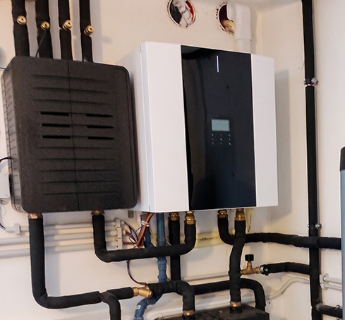Indoor installation of Clivet SPHERA EVO BOX heat pump with 300-liter storage tank in the technical room.