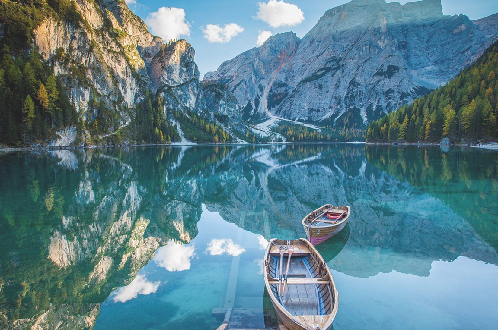 Mountain lake with wooden boats, harmony between people and nature